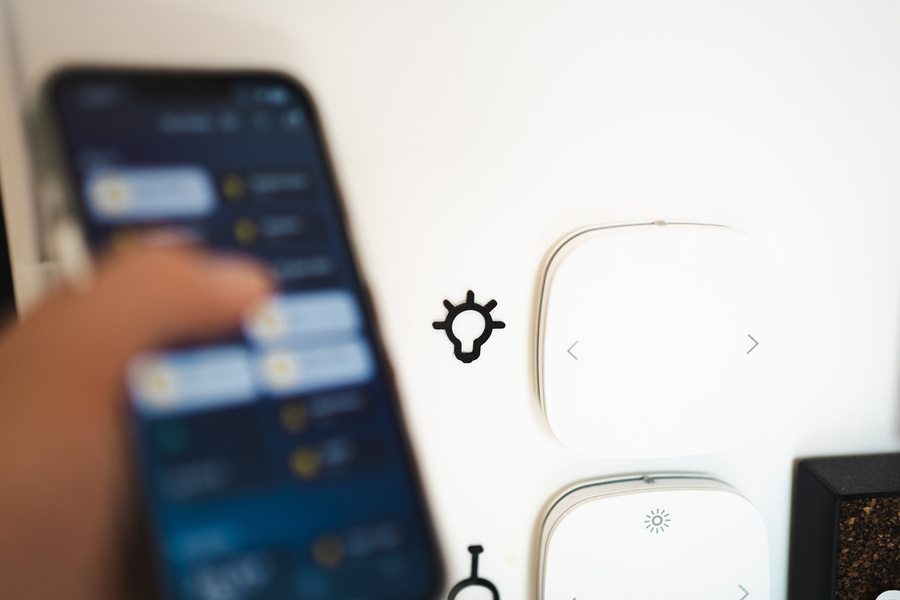 a person is using a phone to control a smart light switch.