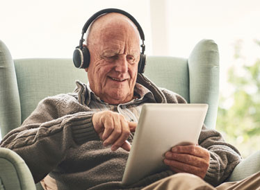 an individual listening to music on a tablet computer and very pleased with the music he has chosen.